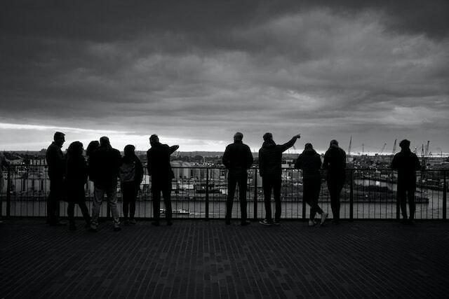 black and white, people pointing out over a river