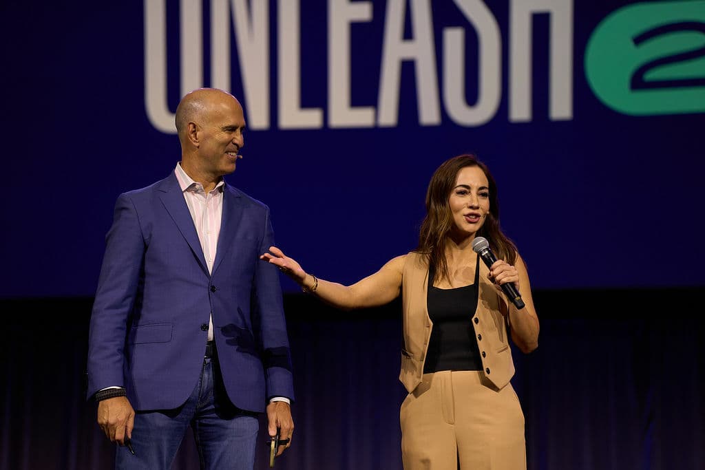 man and woman on stag at an industry conference